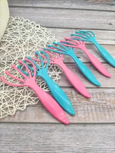Detailansicht von praktischen Kopfhautmassagegeräten aus Kunststoff in Rosa und Blau.