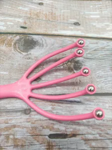 Rosa 5-Zacken Kopfmassagegeraet mit Metall-Rollenkugeln fuer entspannende Kopfhautmassage.