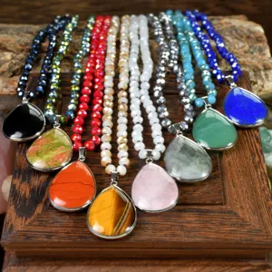 Close-up detail of assorted natural gemstone teardrop pendant necklaces with faceted bead chains.