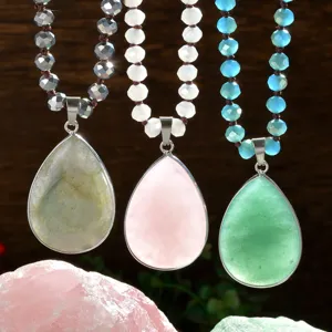 Detailed shot of bohemian natural stone teardrop pendant necklace with faceted crystal beads.