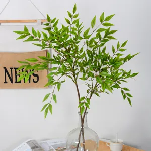 Artificial nandina bamboo leaves plant branches in glass vase for home decor interior styling