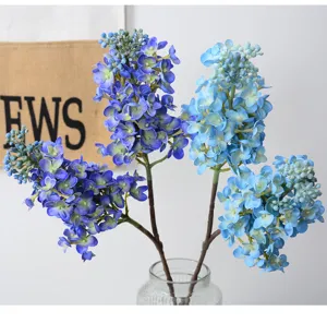 Vue détaillée de bouquet de fleurs de lilas artificielles bleues et violettes dans un vase.
