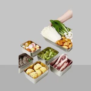 Detailansicht von Edelstahl Vorratsdosen gefuellt mit frischem Gemuese und Obst.