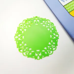 Primo piano dettagliato del sottobicchiere in silicone floreale cavo verde termico.