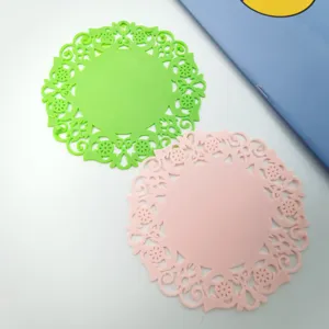 Dettaglio sottobicchiere in silicone a fiore cavo, tappetino termoresistente flessibile.