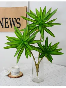 Detailed view of artificial lily bamboo plant in clear glass vase for desktop tropical decor.