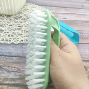 Detailansicht der Plastikreinigungsbürste mit weißen harten Borsten und grünem Griff.