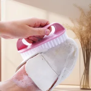 Detailaufnahme einer rosa Kunststoffreinigungsbürste beim Schuhe putzen mit Schaum.