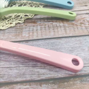 Close-up detail view of multi-functional plastic cleaning brush with convenient hanging hole.
