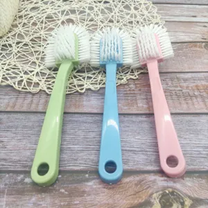 Multi-functional shoe brush detail featuring long handle and durable bristles in three colors.