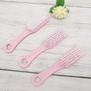 Juego de tres cepillos de limpieza rosas de plástico para zapatos y ropa con cerdas suaves.