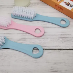 Vista detallada de pequeños cepillos de plástico para limpiar zapatos con cerdas suaves.