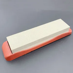 Double sided white corundum whetstone with red non slip silicone base for kitchen sharpening.