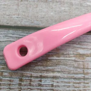 Close-up detail of the pink cleaning brush handle featuring a convenient hanging hole.