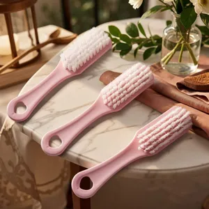 Cepillo de limpieza rosa con cerdas suaves para zapatos y ropa, práctico utensilio.