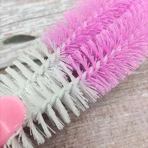 Close-up detail view of multi-purpose cleaning brush with pink and white bristles.