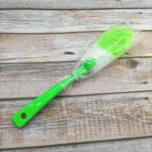 Detailed view of the long handled multi functional cleaning brush with green bristles and handle.