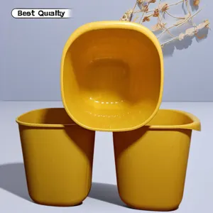 Vista dettagliata del secchio portaoggetti quadrato in plastica gialla dal design aperto.