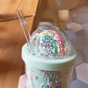 Nahaufnahme des schönen Regenbogen-Domdeckels mit Glitzersternen am doppelwandigen Kunststoffbecher.
