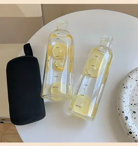 Clear glass water bottle with time markers and protective sleeve for daily hydration goals.