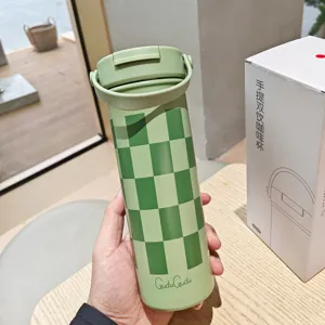 Grüner karierter Thermobecher im Detail, tragbarer Edelstahl Kaffeetasse mit Henkel.