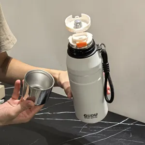 Primo piano della borraccia sportiva termica bianca portatile con cinturino nero e tazza.