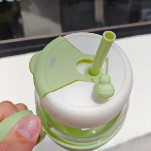 Close-up detail of glass straw cup lid, dual drinking design with green cap and cute stopper.