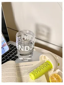 Vue détaillée du gobelet d'eau en plastique portable avec infuseur et esthétique de bureau propre.