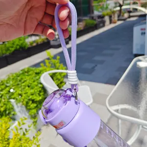 Vista di dettaglio della borraccia in plastica viola con cordino intrecciato e pratico tappo.