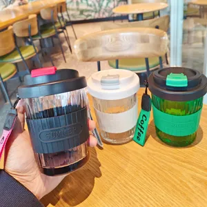 Detailed view of portable glass coffee cup, stylish design with anti-scald sleeve.