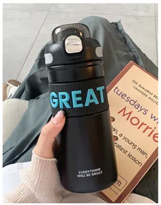 Primer plano detallado de taza térmica negra con letras azules en relieve y práctico diseño de paja.
