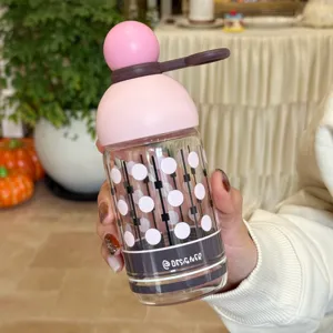 Moderne Glas-Trinkflasche mit süßem rosa runden Deckel und stilvollem Pünktchenmuster.
