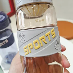 Vista dettagliata di una bottiglia sportiva in plastica trasparente con fascia in silicone grigio.
