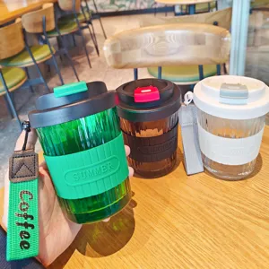Portable glass coffee cup with silicone sleeve, heat-resistant travel water tumbler with strap.