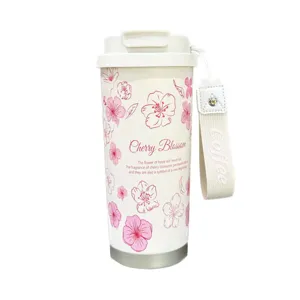 Insulated thermal coffee cup with cherry blossom floral pattern, portable strap and secure lid.