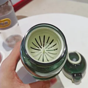 Vista dettagliata della borraccia sportiva in plastica portatile con infusore per tè verde.