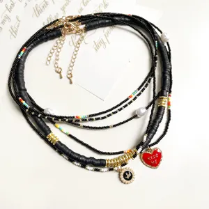 Mehrlagige Perlenkette mit Herzanhänger, schwarzen Scheibenperlen und elegantem Choker-Design.