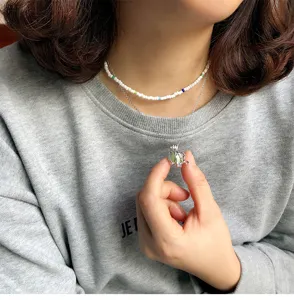 Detailed shot of double layer beaded and elephant pendant necklace worn by model