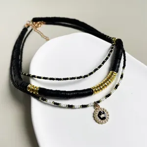 Mehrlagige schwarze Perlen-Kette mit goldenen Akzenten und Kronen-Anhänger für Damen.