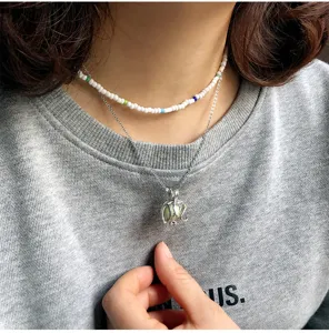 Detail view of double-layer vintage necklace with beaded choker and luminous pendant.
