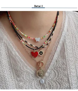 Close-up detail of multi-layer beaded necklace set featuring charming pendants and chains.
