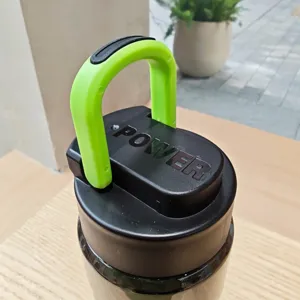 Gedetailleerde close-up van de tritan sport waterfles dop met groene handgreep en zwart deksel.