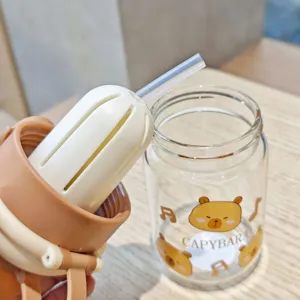 Close-up detail of cute capybara glass water bottle with straw and tea filter lid.