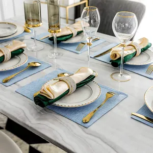 Detailed view of elegant faux linen fabric placemats on a marble dining table with luxury tableware.