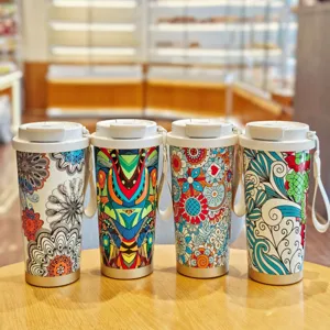 Taza de café térmica estilo bohemio con correa portátil y coloridos patrones de mandalas.