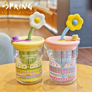 Süßer Glas-Wasserbecher mit Gänseblümchen-Strohhalm und Tee-Ei, farbenfrohes Design für Büroalltag.