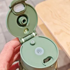 Nahaufnahme des grünen Trinkbecherdeckels mit Strohhalm, zeigt die Silikondichtung.
