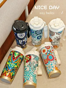 Primer plano de elegantes tazas de viaje térmicas de estilo bohemio con coloridos diseños.