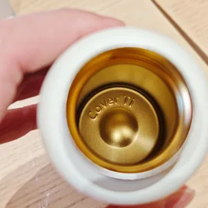 Detalle interior de taza de agua al vacío de titanio con forro dorado y elegante grabado.