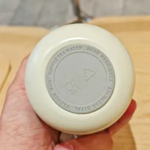 Bottom detail view of stainless steel vacuum mug showing product specifications text
